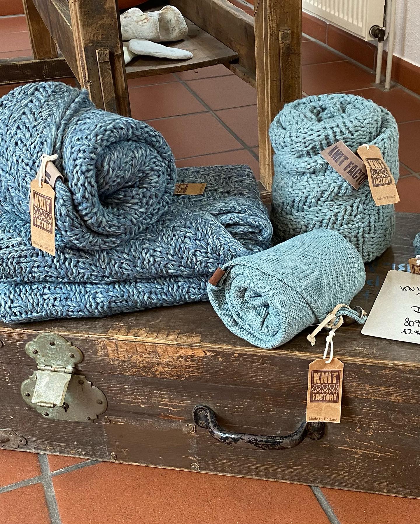 Blaue und Grünblaue Schals auf einer Holztruhe